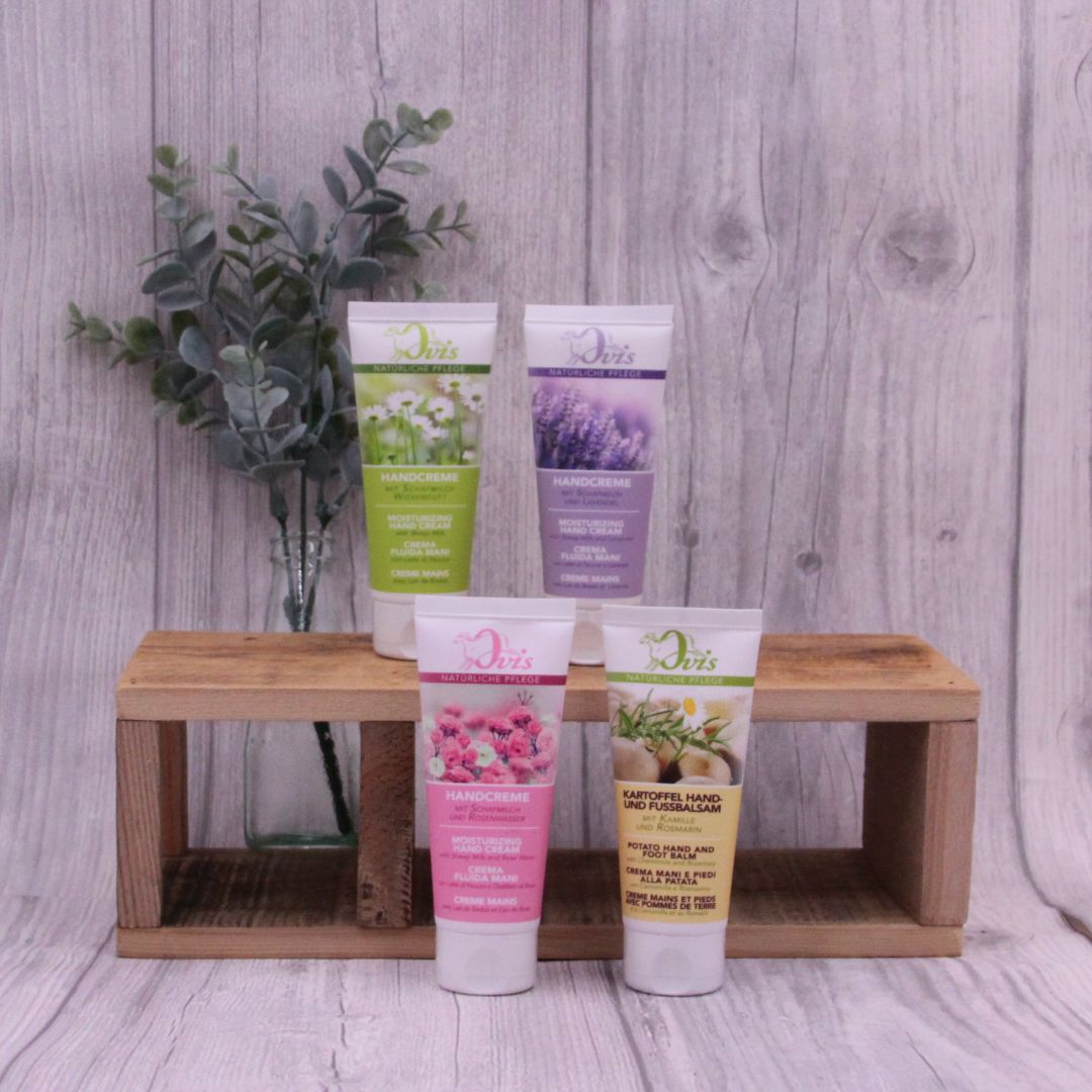 Handcreme in Tube, verschiedene Sorten, auf und vor Holzregal stehend